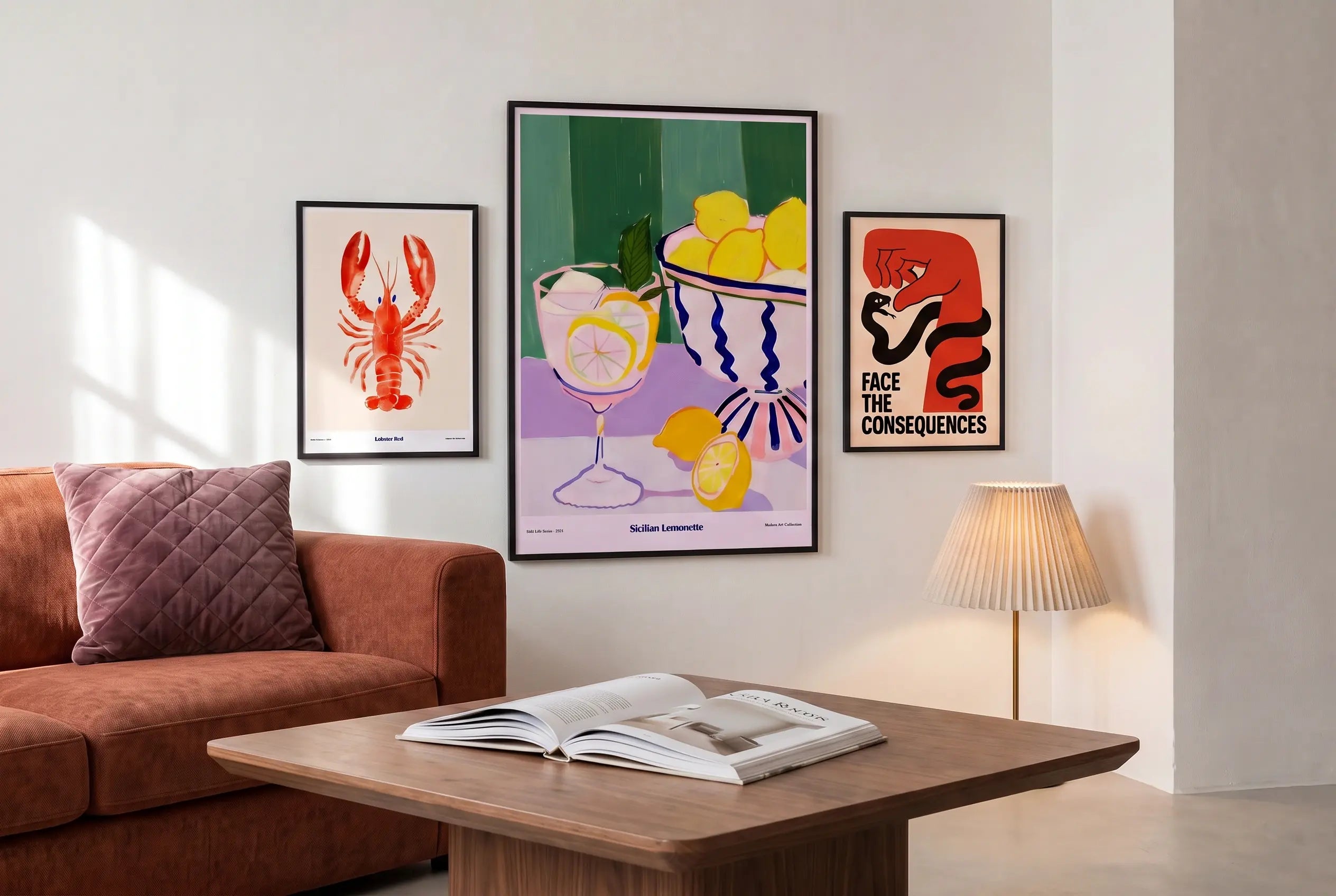 Modernes Wohnzimmer mit drei gerahmten Wandpostern – Lobster Red Illustration, Sicilian Lemonette Stillleben und Face The Consequences Typografie-Poster – über einem Samtsofa mit Holzcouchtisch